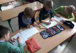 Dzieci malują kredkami na kartonach, w jaki sposób należy dbać o środowisko